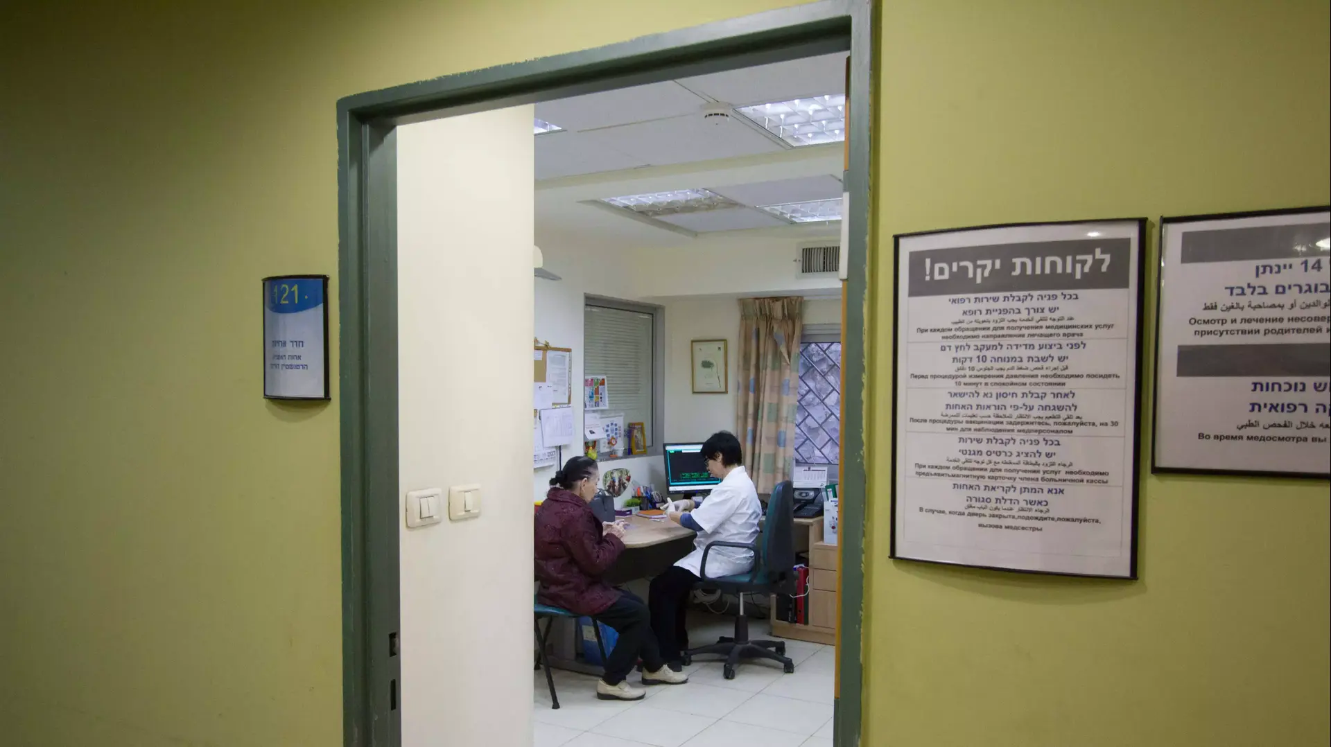אנשים מתחסנים לשפעת בסניף קופת חולים לאומית בתל אביב