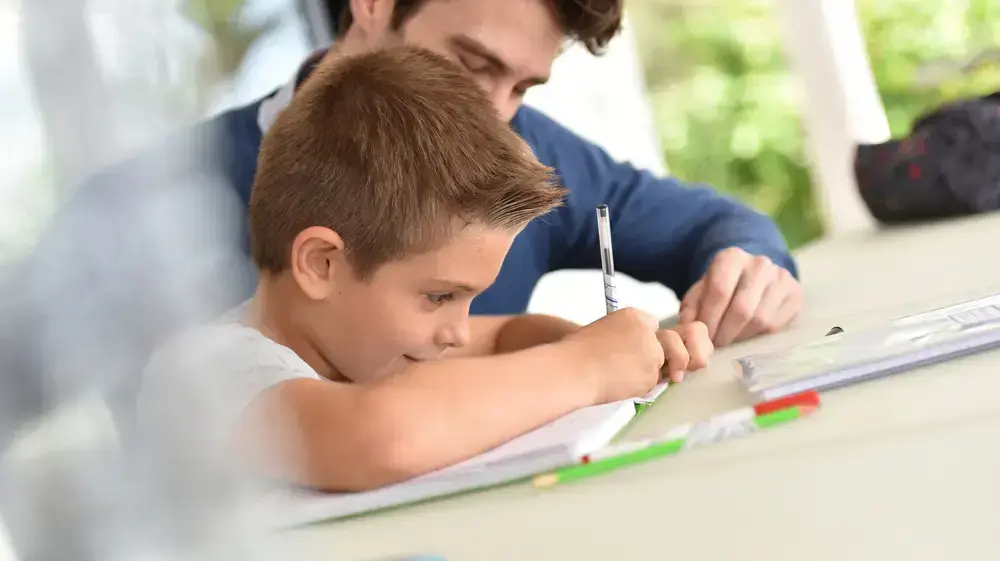 ילד מכין שיעורי בית