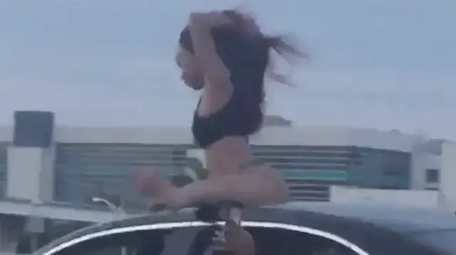 בחורה עושה טוורקינג על גג רכב נוסע