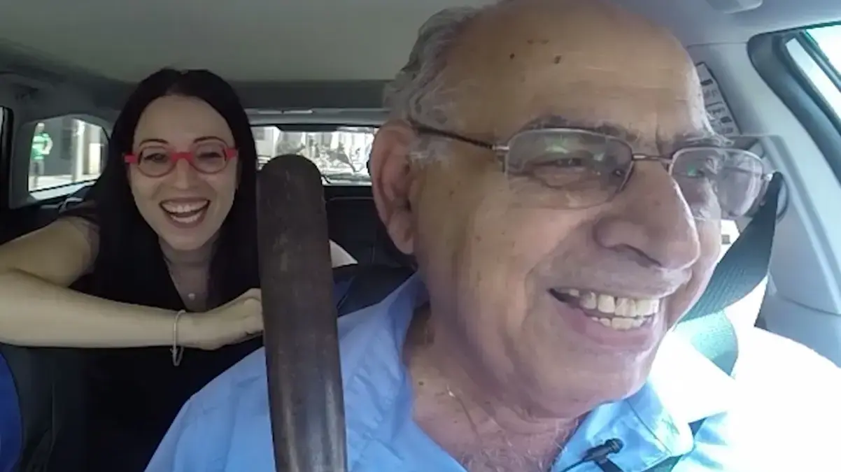 בת אל בלן עם נהג מונית שמחזיק אלה