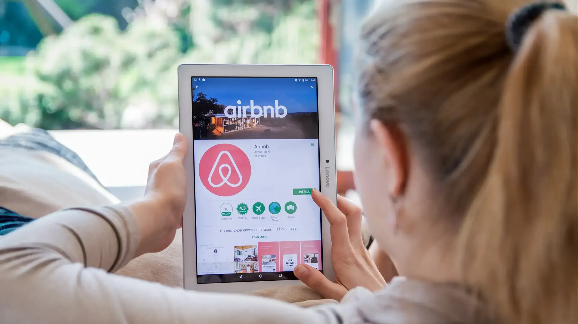אישה גולשת באתר Airbnb באמצעות טאבלט