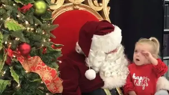 ילדה קטנה יושבת על סנטה קלאוס