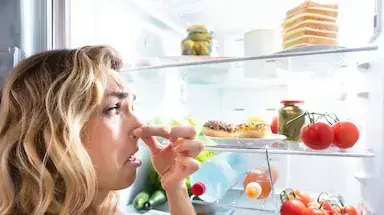 אישה נגעלת מתכולת המקרר