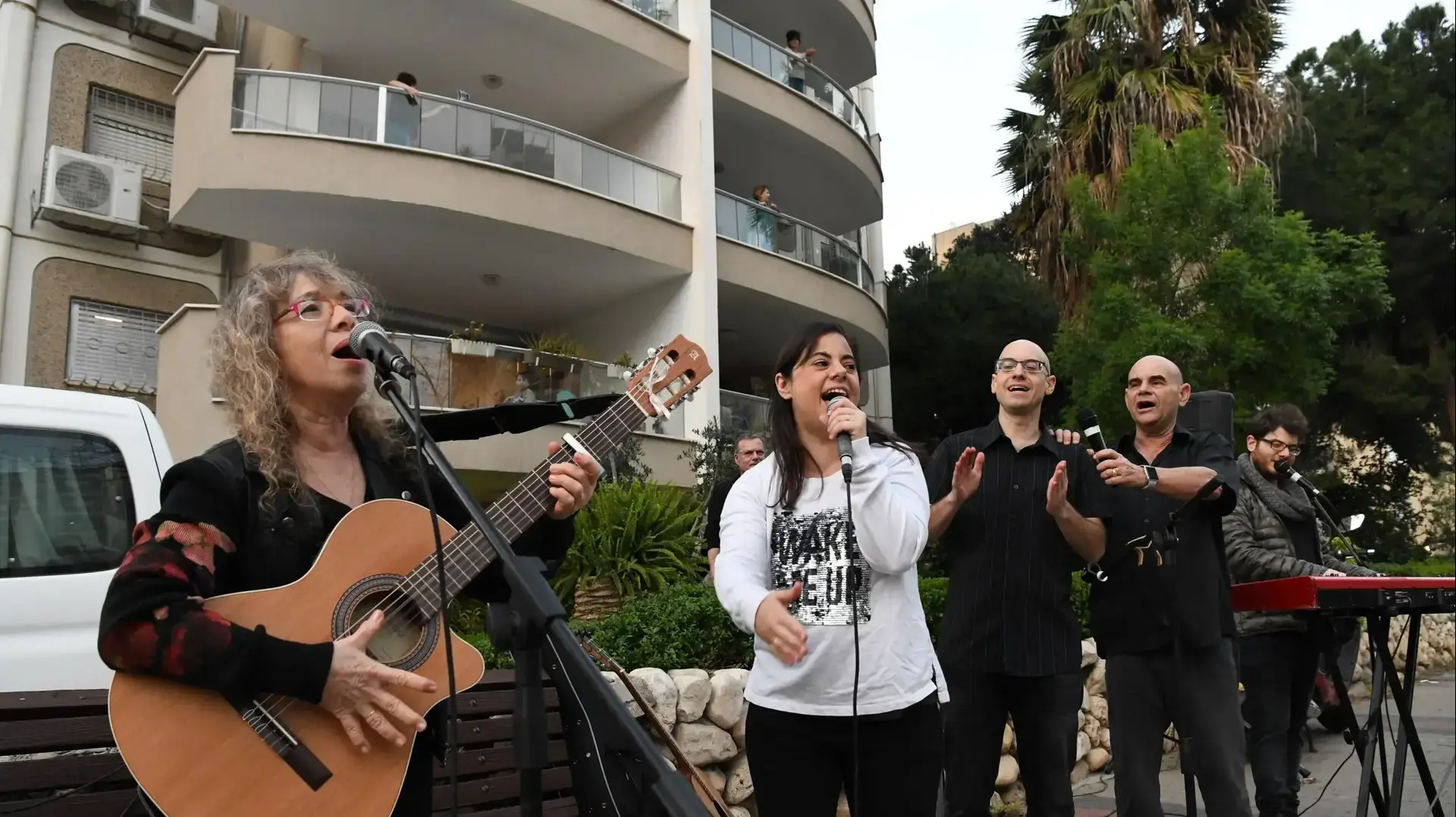 דורית ראובני, יעקב (יענק'לה) מנדל וילדיהם טל אסי ומור מופיעים ברחוב מגוריהם בשכונת הדר יוסף בתל אביב על רקע איסור ההתקהלות ומניעת הופעות בשל התפשטות נגיף הקורונה, 15 במרץ 2020
