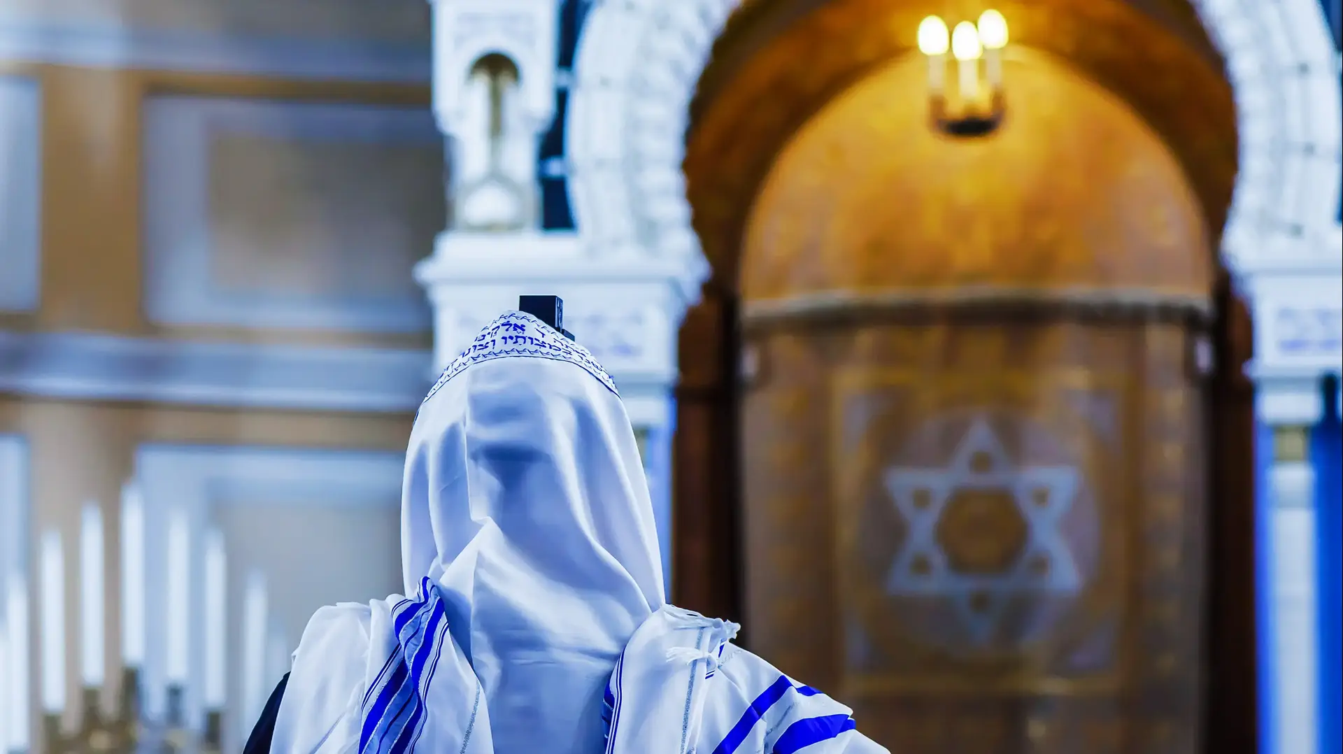 יהודי מתפלל בבית כנסת עם טלית