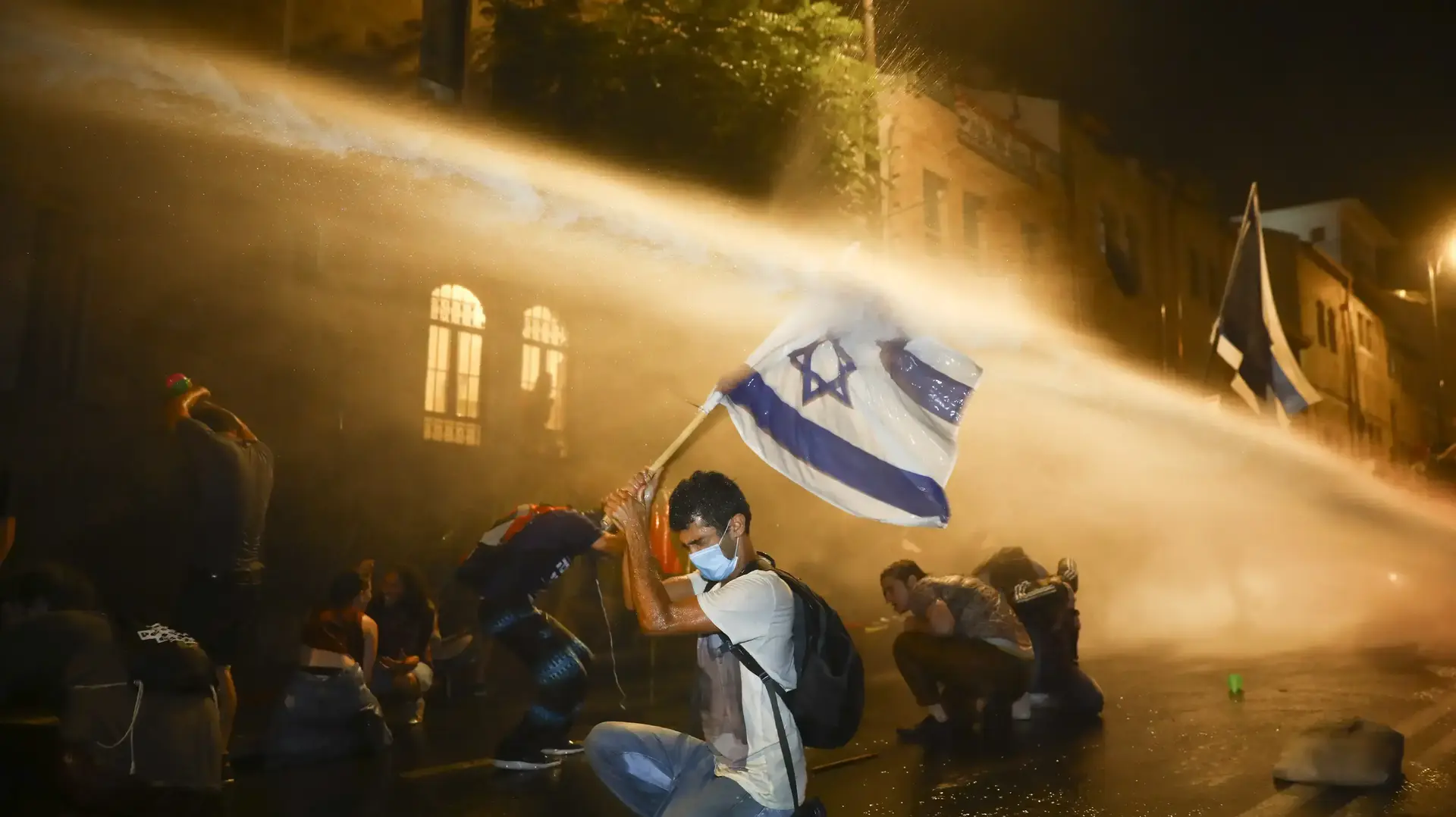 צילום של עודד בלילטי ל-AP, שהיה אחד משני הזוכים בתערוכת "עדות מקומית 2020" בתואר תמונת השנה. בצילום נראים מפגינים שמתעמתים עם כוחות הביטחון במהלך הפגנה נגד ראש הממשלה, בנימין נתניהו, בסמוך לביתו בירושלים, ב-18 ביולי 2020