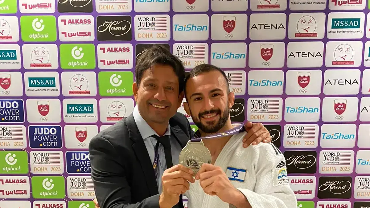 הג'ודוקא הישראלי ברוך שמאילוב אחרי שזכה במדליית כסף בדוחא לצד מאמנו אורן סמדג'ה