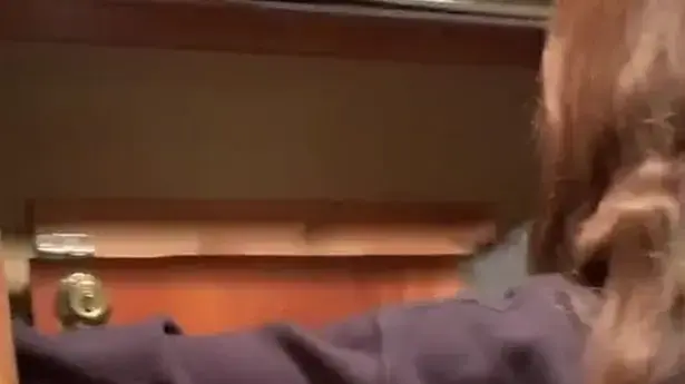 אישה חושפת חדר נסתר בארון הבגדים שלה