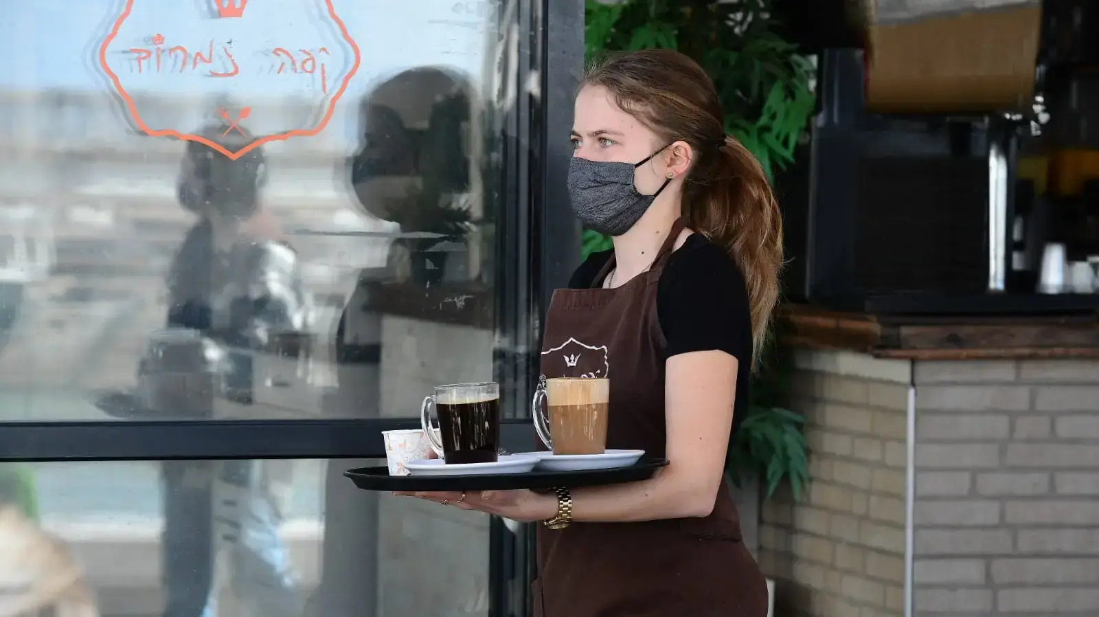 מלצרית בקפה נמרוד עם פתיחת בתי קפה ומסעדות בנמל ת"א, 7 במרץ 2021