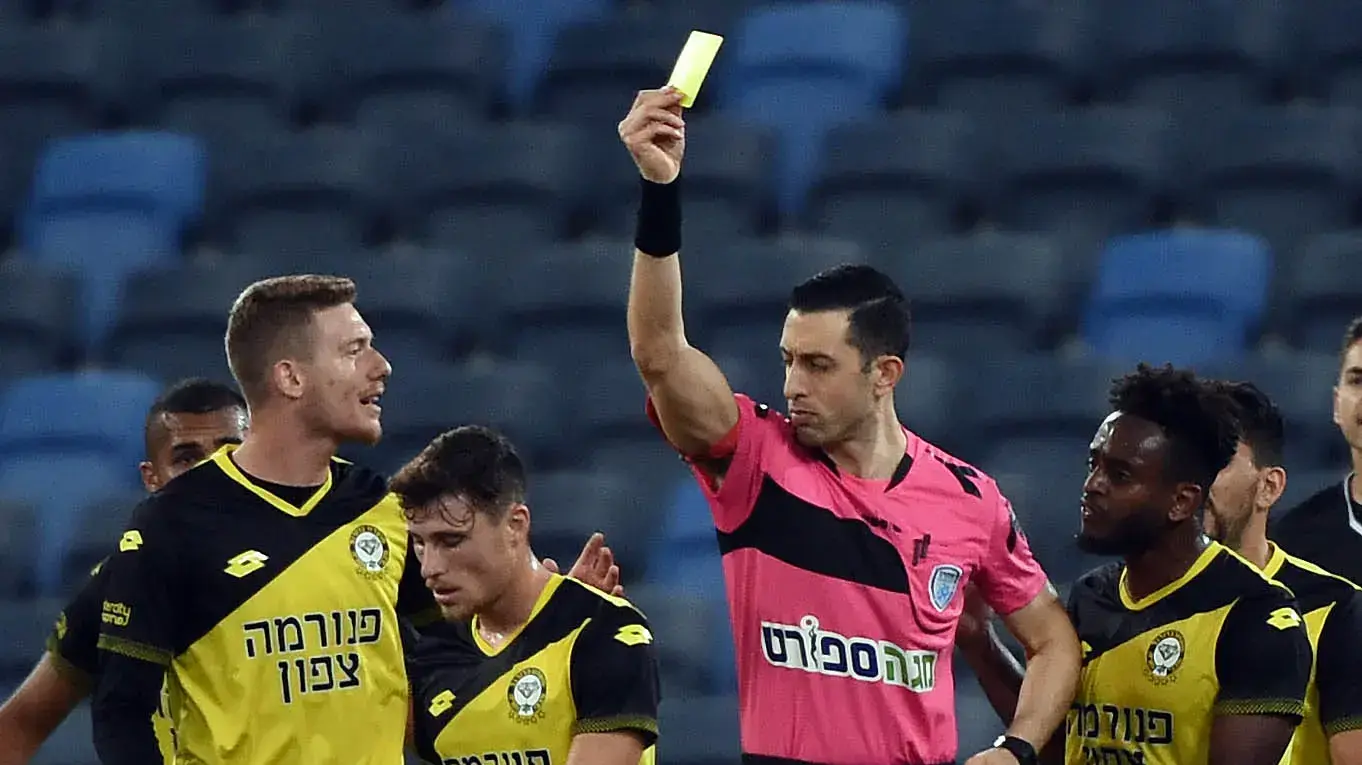 השופט אביעד שילוח שולף כרטיס צהוב לעבר גבי קניקובסקי שחקן מכבי נתניה
