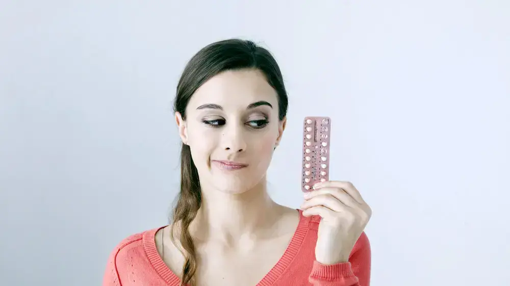 אישה מחזיקה חפיסת גלולות למניעת היריון