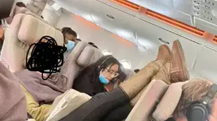 נוסעת בטיסת אמירייטס מניחה רגליים על המושב נוסעת בטיסת אמירייטס מניחה רגליים על המושב