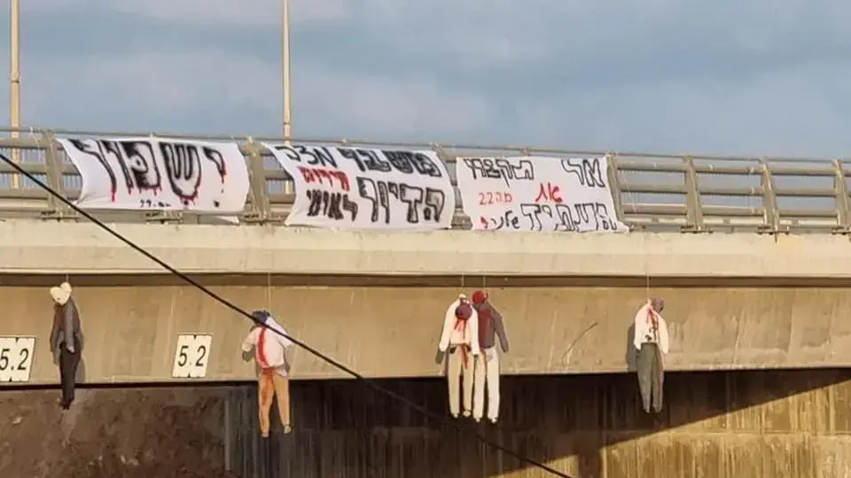 מפגינים ממחאת הדיור קשרו הבוקר דמויות תלויות לגדר הגשר במחלף בית ינאי בכביש החוף, בליווי שלטים עם הכיתוב ״אל תקברו את העתיד שלנו״ ו״ישכור״