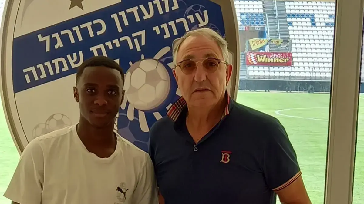 טימו מוזי מוצג כשחקן עירוני קרית שמונה עם הסוכן ג'קי דהאן