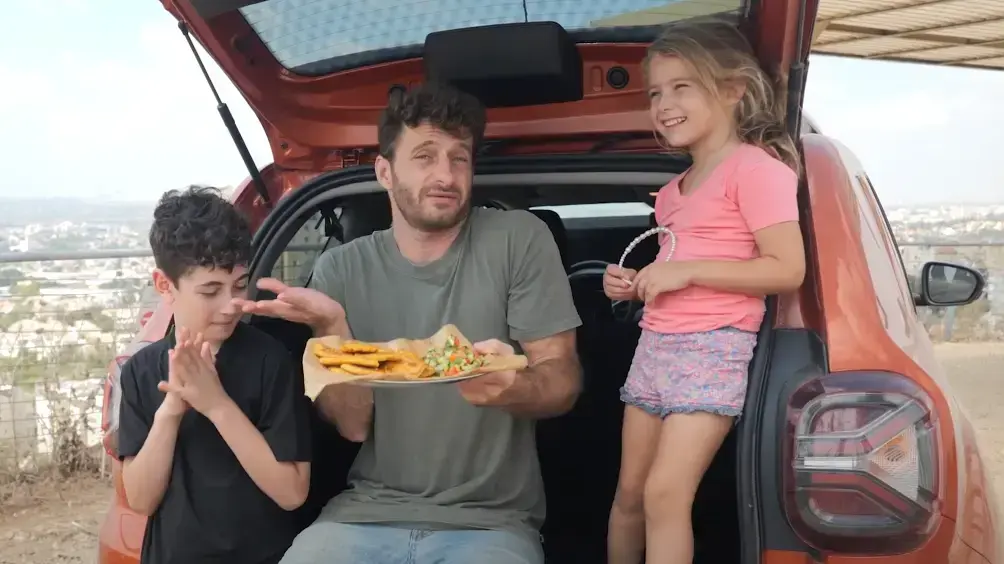 אושר אידלמן מכין לביבות תירס בשטח עם דאצ'יה דאסטר