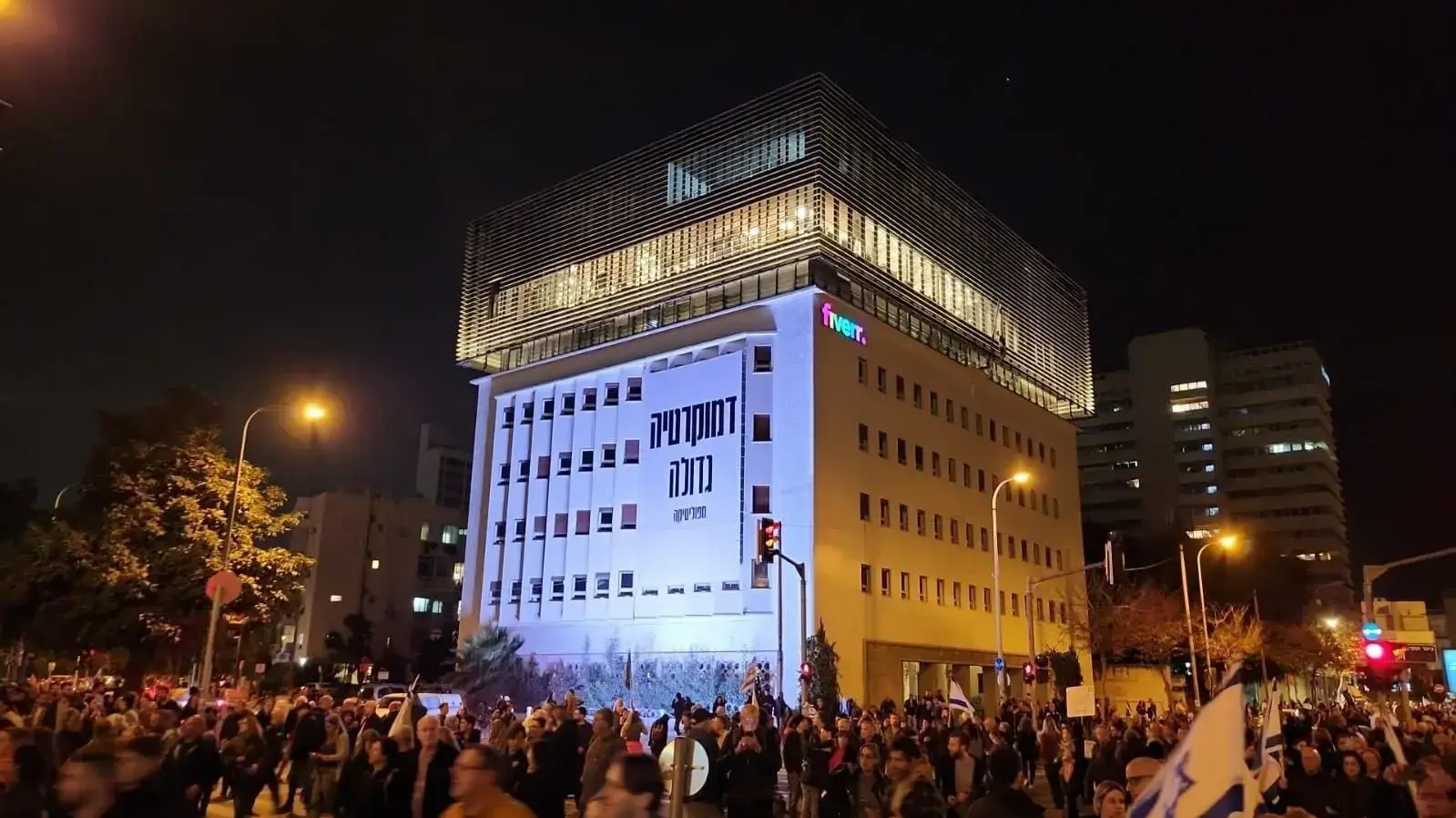 בניין פייבר בת"א ועליו שלט התמיכה במחאה החברתית.