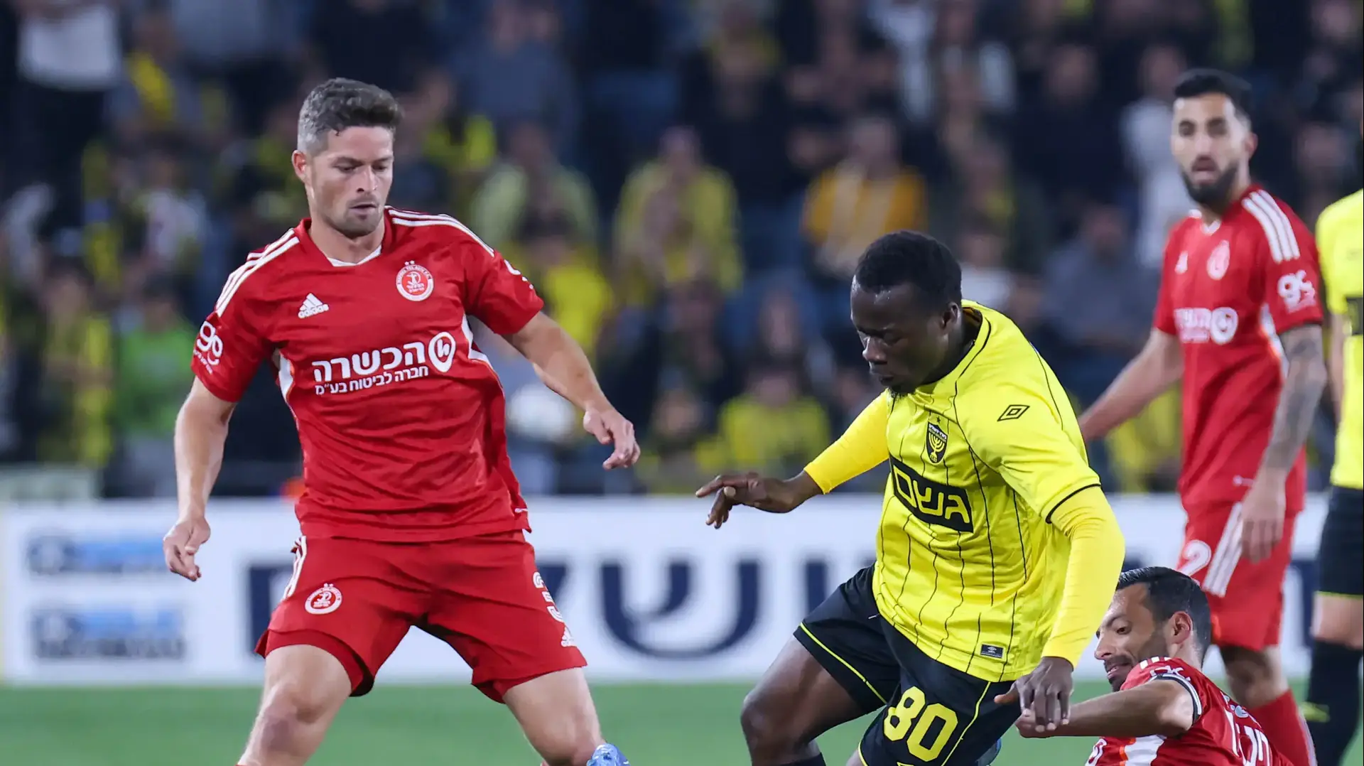 שחקן בית"ר ירושלים טרזייה תומא בין שחקני הפועל תל אביב: דן איינבינדר, דוד קלטינס