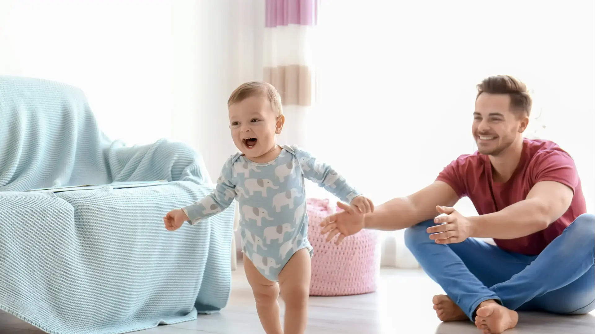 אבא עם תינוקת שעושה את צעדיה הראשונים