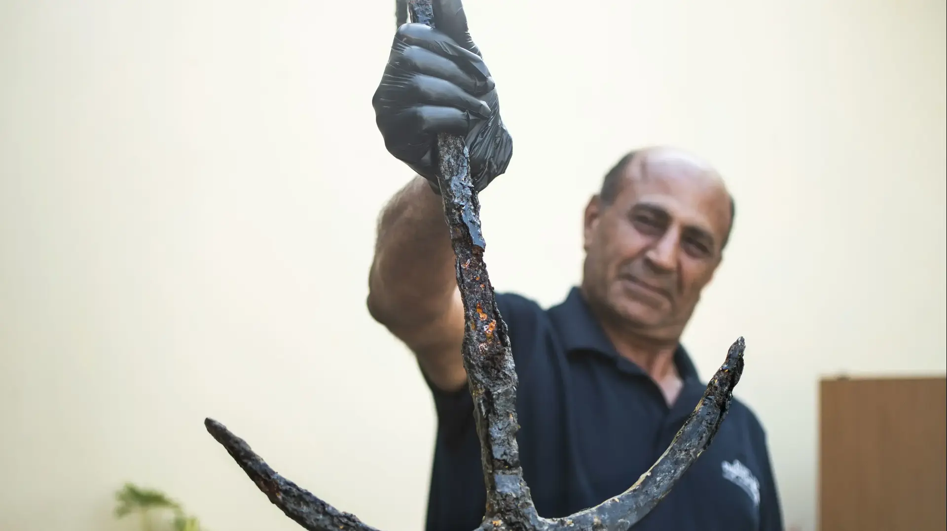 מרואן מסארווה ארכיאולוג רשות העתיקות עם עוגן בן 1700 שנה שהוחזר