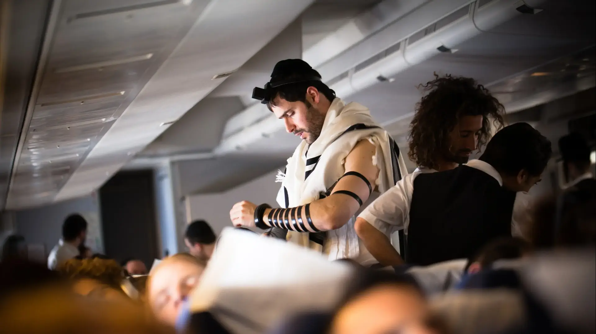 בחור יהודי צעיר מתפלל במהלך טיסה