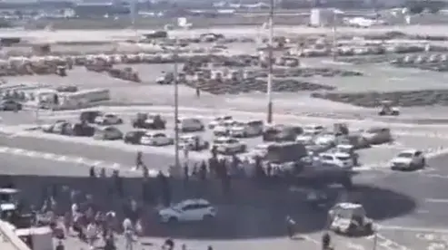 נוסעים אוספים את מזוודותיהם משטח המראת המטוסים בנתב"ג, 4 באוגוסט 2023