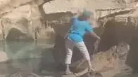 תיירת טיפסה אל מזרקת טרווי ברומא כדי למלא מים