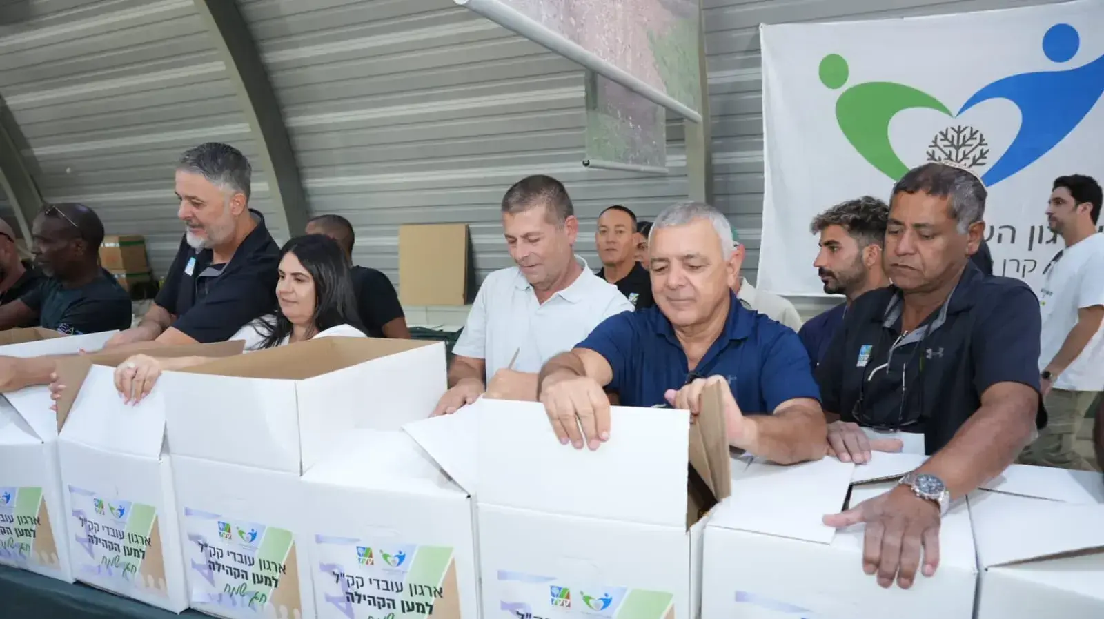 עובדי קק"ל אורזים סלי מזון למשפחות קשות יום