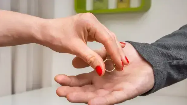 אשה מניחה טבעת נישואים ביד של גבר