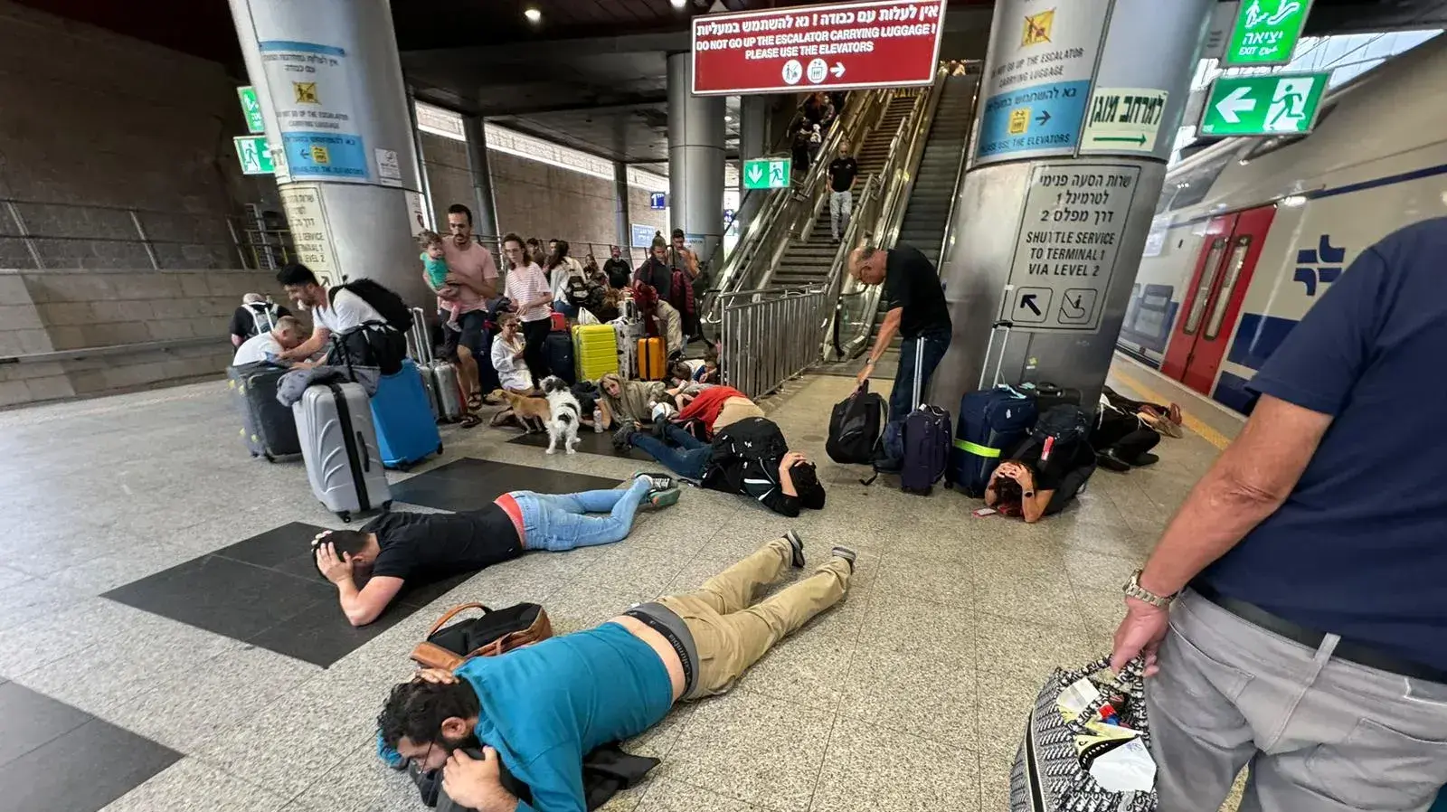 נוסעים בתחנת הרכבת שוכבים על הרצפה בעת אזעקה, נתב"ג, 9 באוקטובר 2023