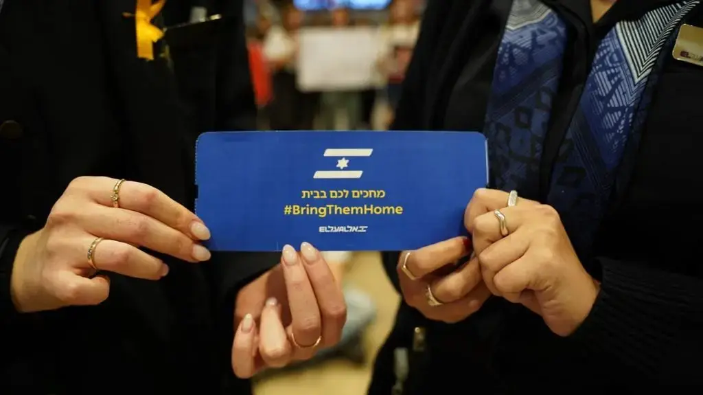 כרטיס טיסה של אל על עם כיתוב להשבת החטופים בעזה