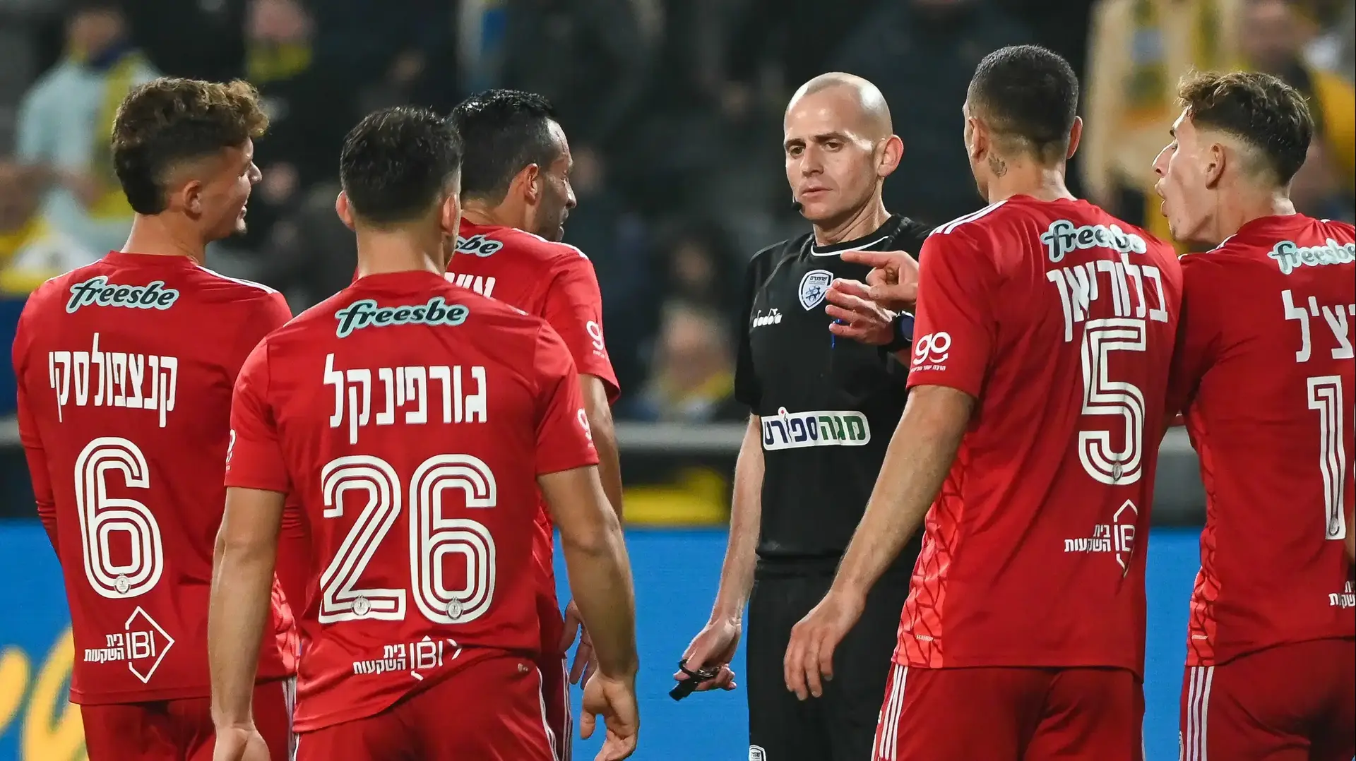 שחקני הפועל תל אביב עם השופט עידן לייבה