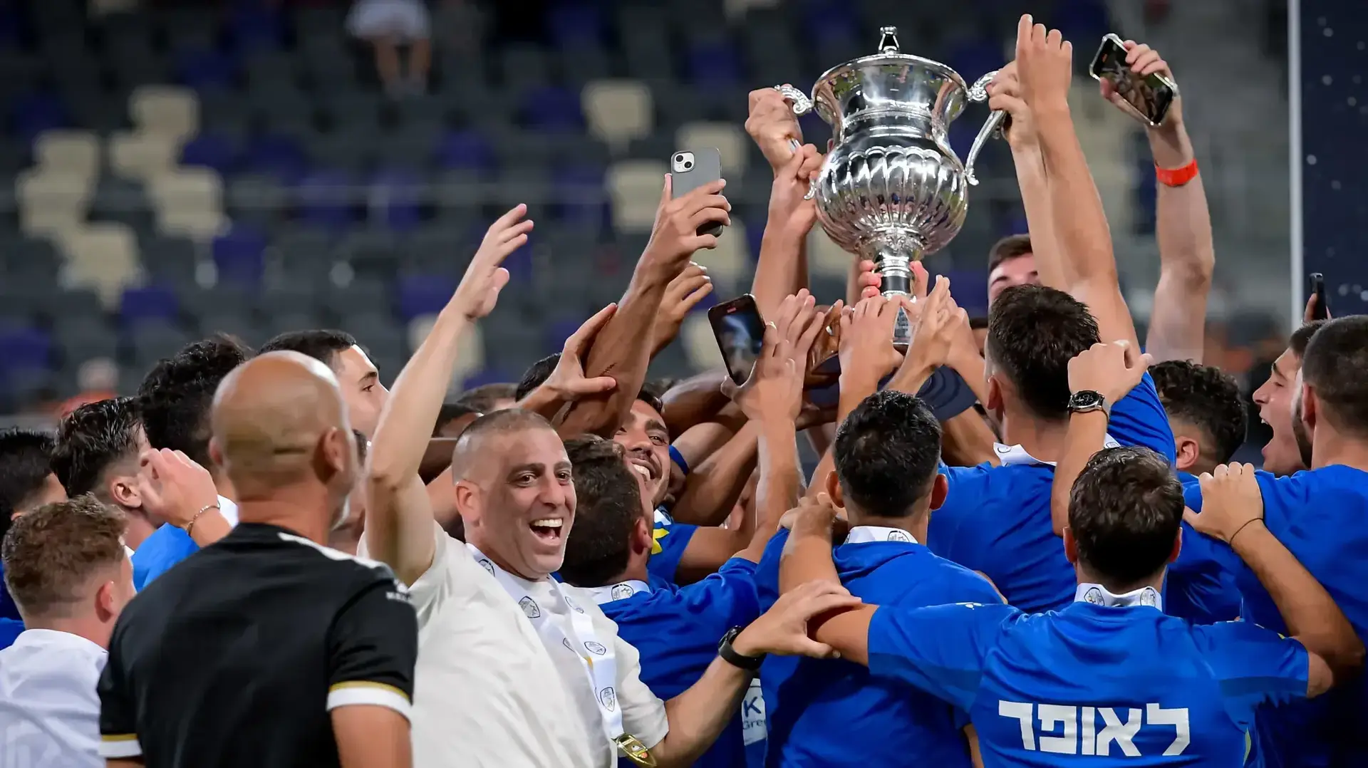 שחקני מכבי פתח תקוה מניפים את גביע המדינה 2024, המאמן רן קוז'וך מקדימה