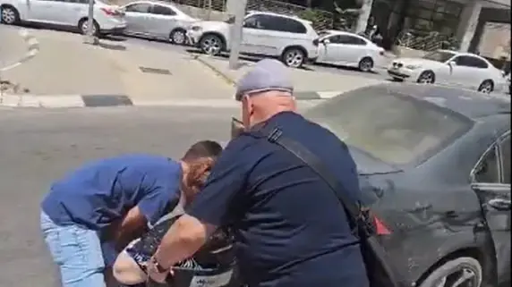 אזרח עוזר לבני זוג לחצות את הכביש בקריית הממשלה בבאר שבע