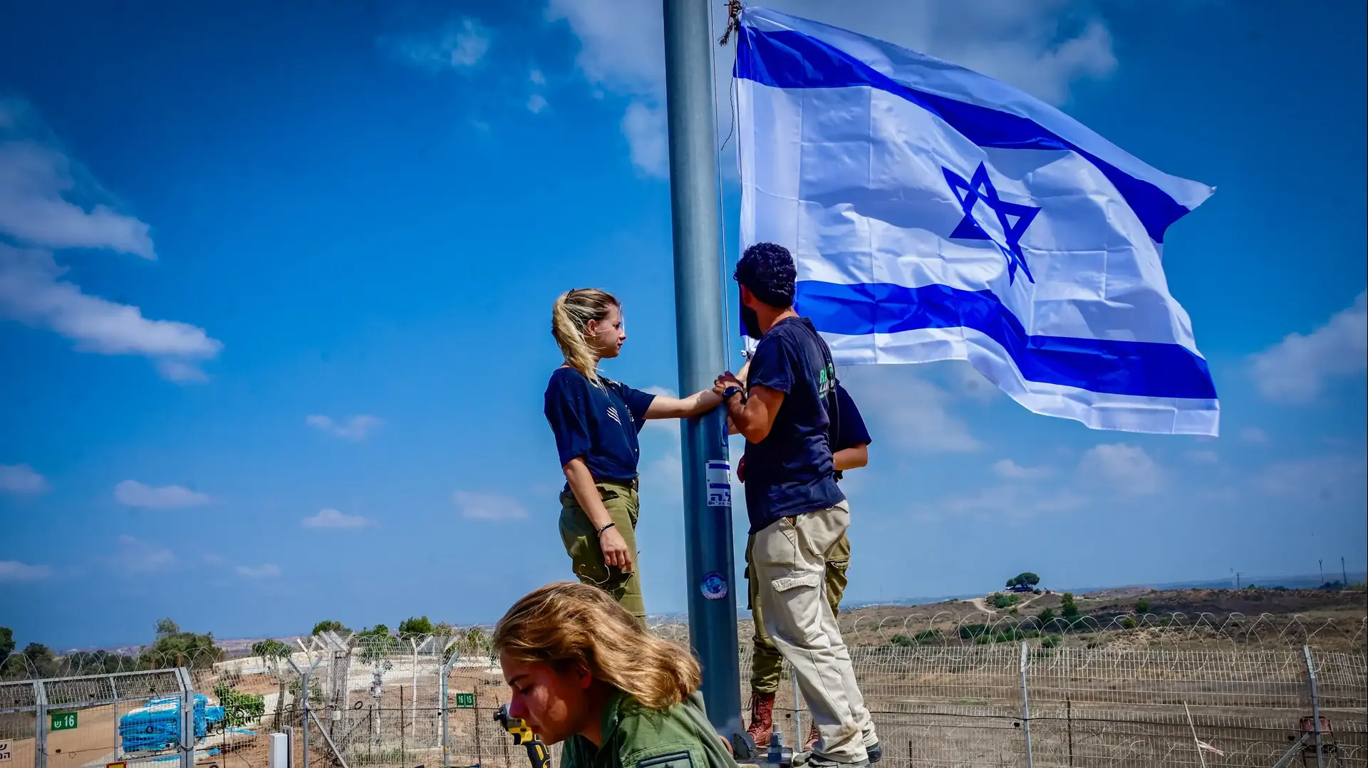 חיילים מניפים דגל ישראל בקיבוץ ניר עם