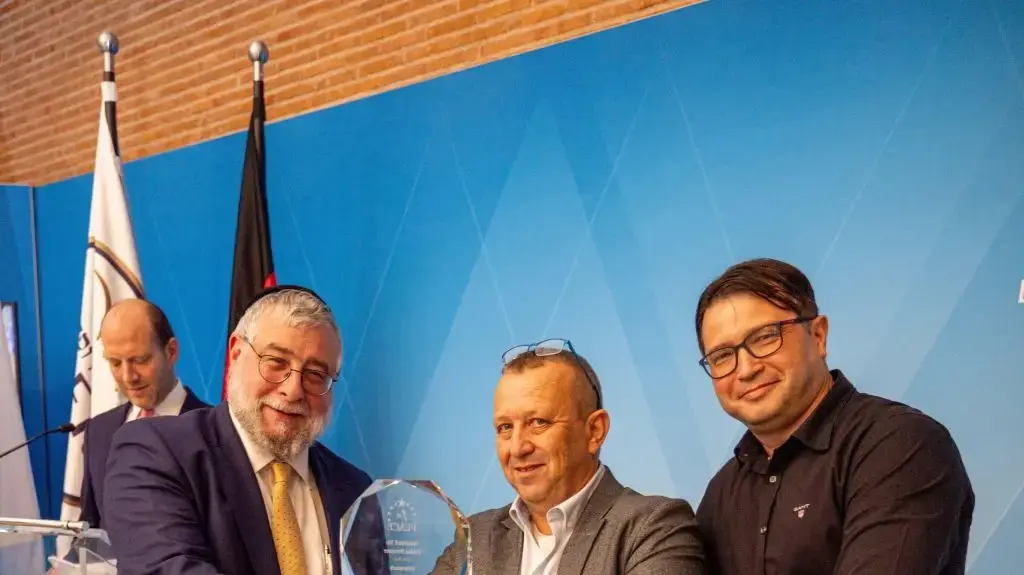 מימין לשמאל: הזוכים בפרס במקום הראשון אדי פווזנר ואלכס דויטש מ-Otterpack ונשיא ועידת רבני אירופה הרב פנחס גולדשמידט.