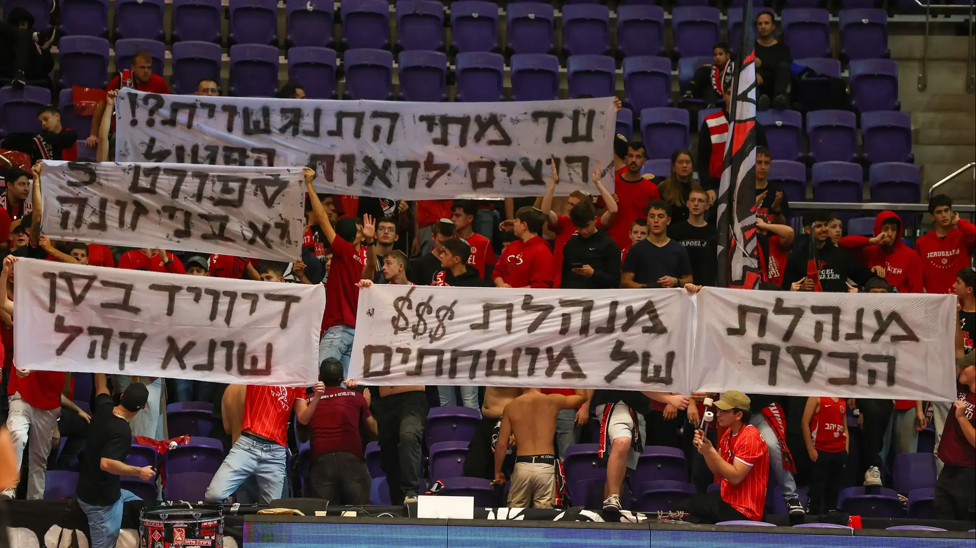 אוהדי הפועל ירושלים מניפים שלטים נגד מנהלת הליגה בכדורסל