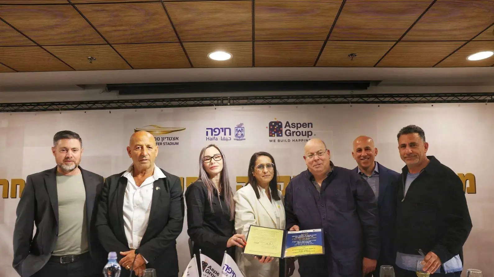 מימין לשמאל: שלומי עקריש מבעלי אספן גרופ, גיא פרג יו"ר דירקטוריון אספן גרופ, גדי מרגלית מנכ"ל עיריית חיפה, שרית גולן סגנית ראש העיר, סופי נקש מ"מ ראש העיר וסגנית ראש העיר, צביקה ברבי, יו"ר דירקטוריון סמי עופר, ליאור פרי מנכ"ל אצטדיון סמי עופר