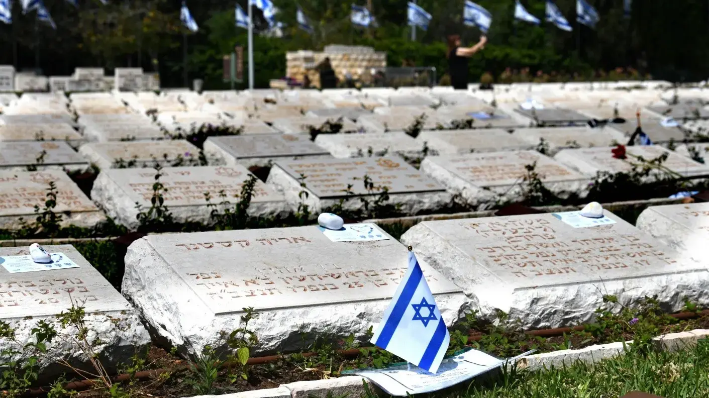 דגלי ישראל על קברי חיילים, לקראת טקס יום הזיכרון לחללי צה"ל, בית עלמין נחלת יצחק, 29 באפריל 2025
