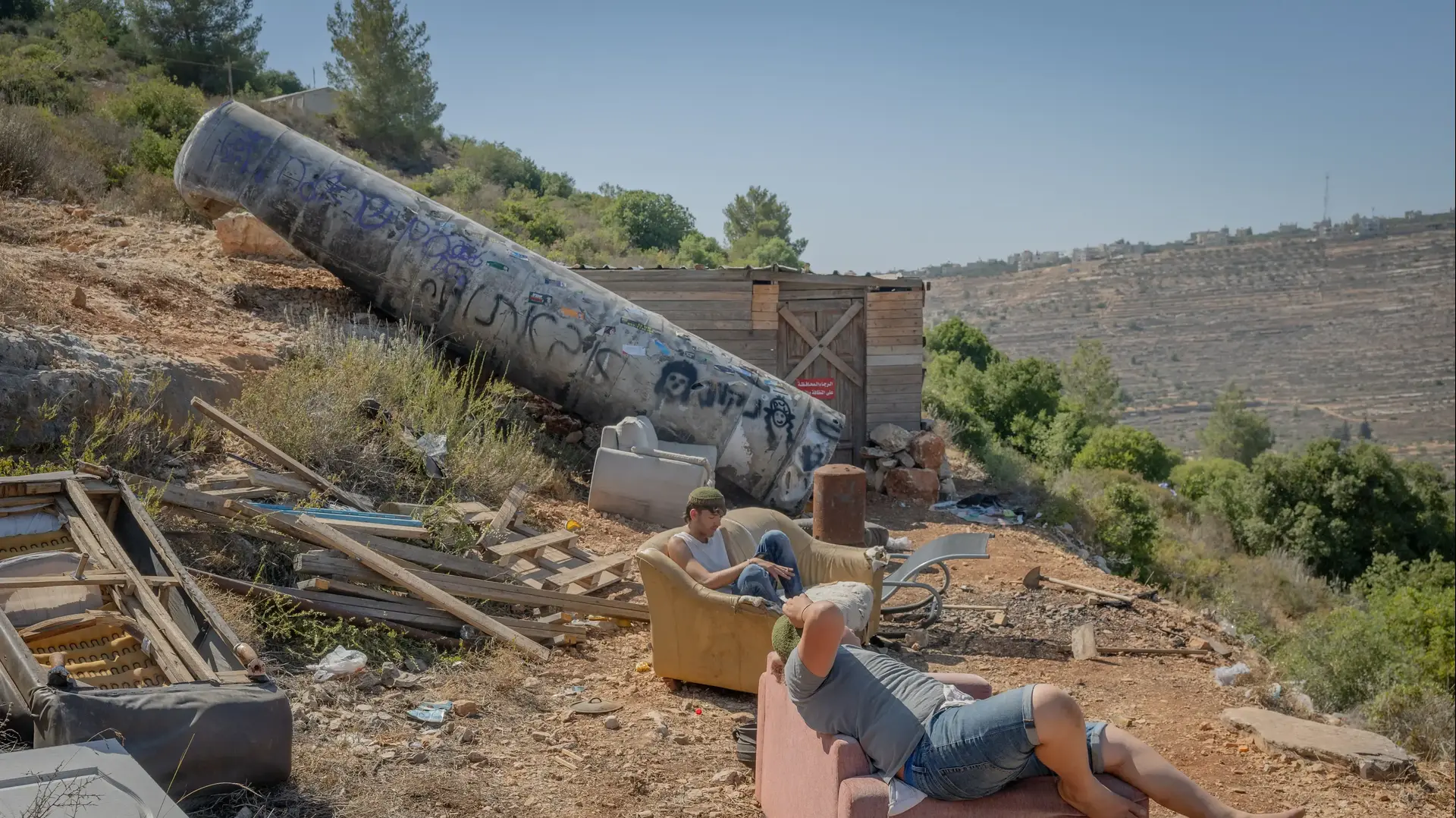 צעירים ליד חלק של טיל ששוגר מאיראן, 29 ביוני 2025