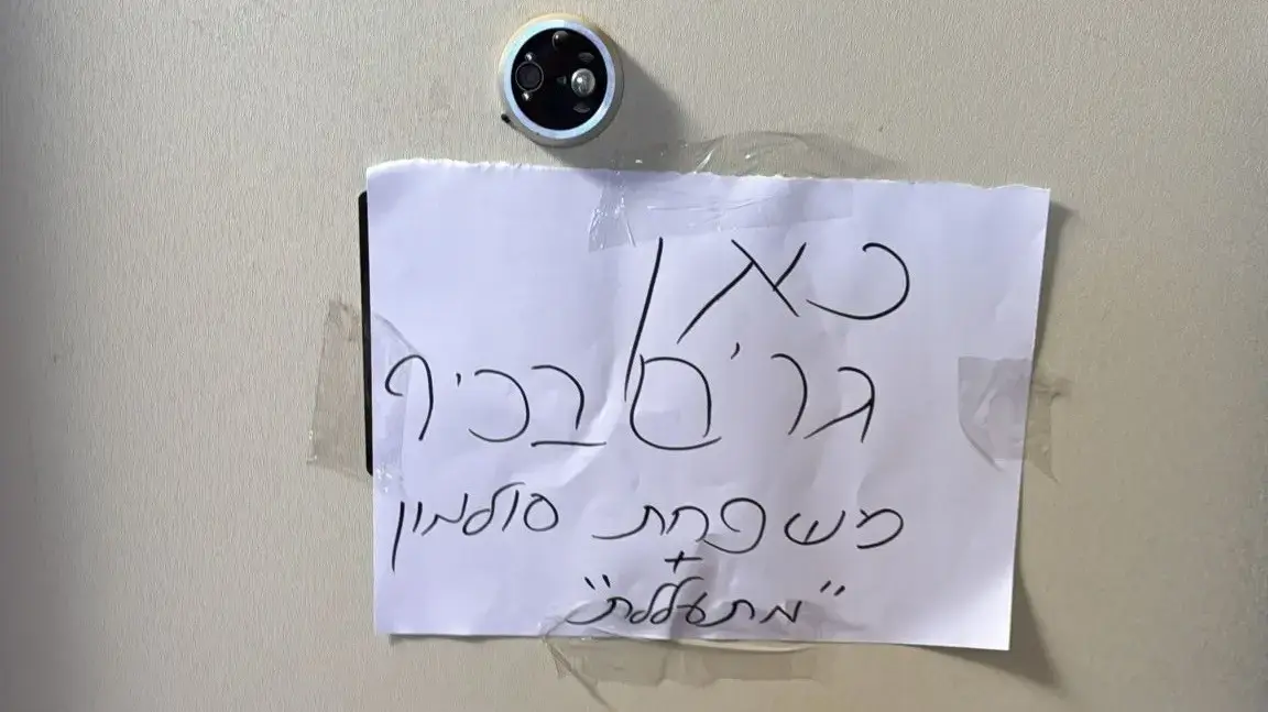 שלט על דלת ביתה של אחת הנאשמות בהתעללות במצפה רמון