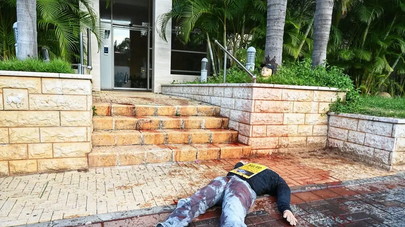 מיצג של ראשים כרותים וגופות "מדממות" שהוצב מול בתיהם של רון חולדאי, עוזי פוגלמן ואהרן ברק. 19 בדצמבר 2025