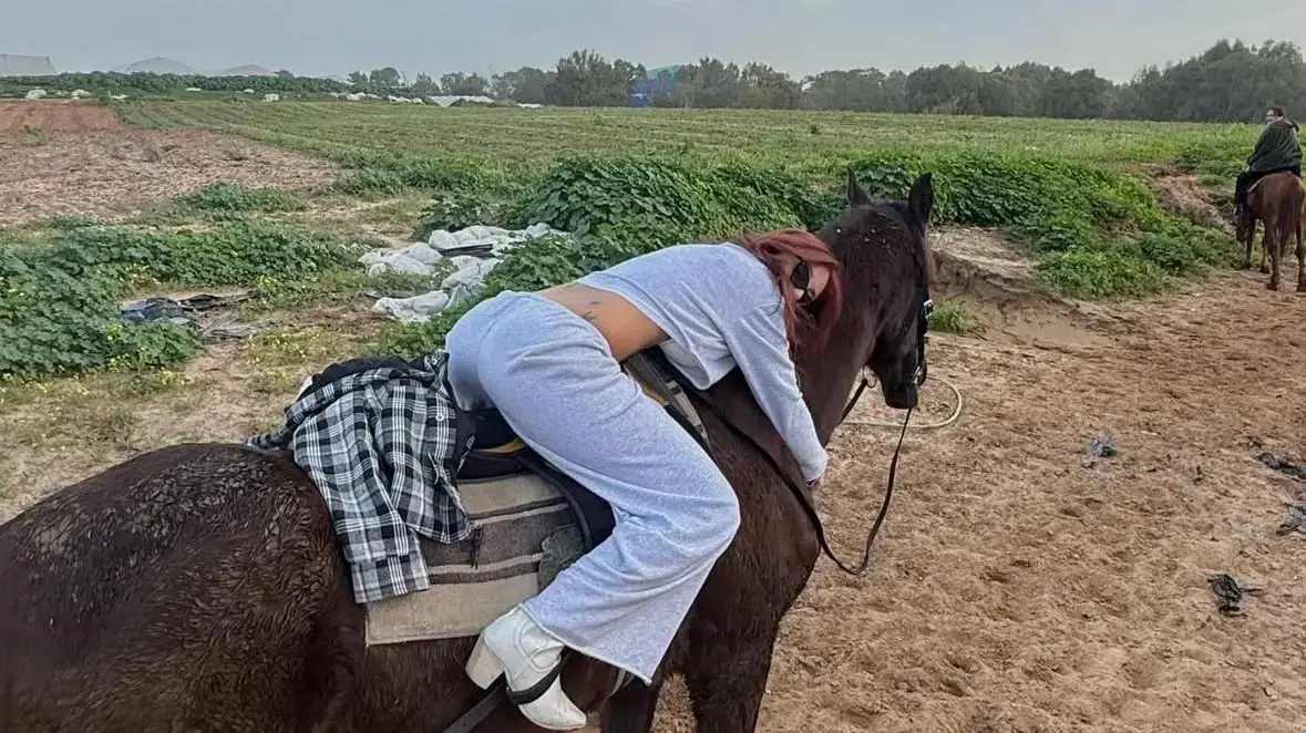מאי ערב רוכבת על סוס