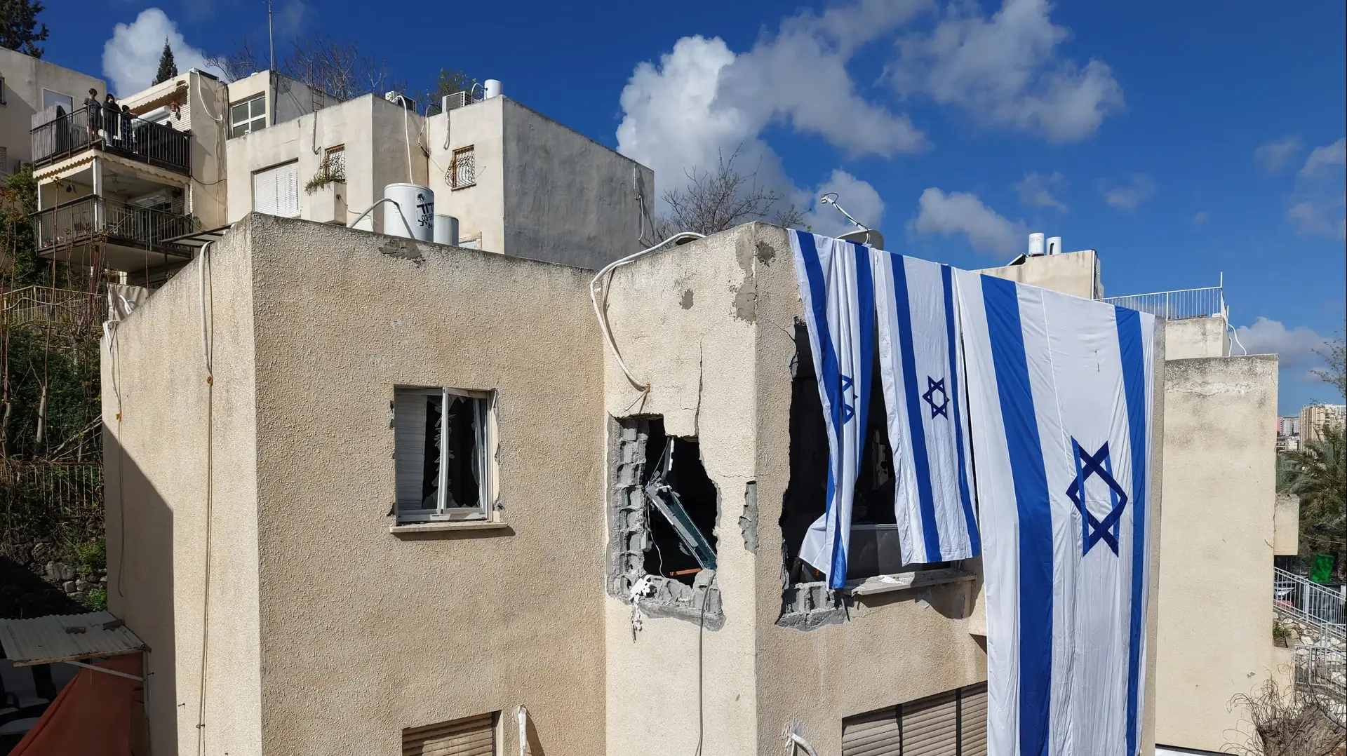 דגל ישראל פרוס על בניין שניזוק במהלך מתקפת טילים אירנית, נשר, 24 במרץ 2026