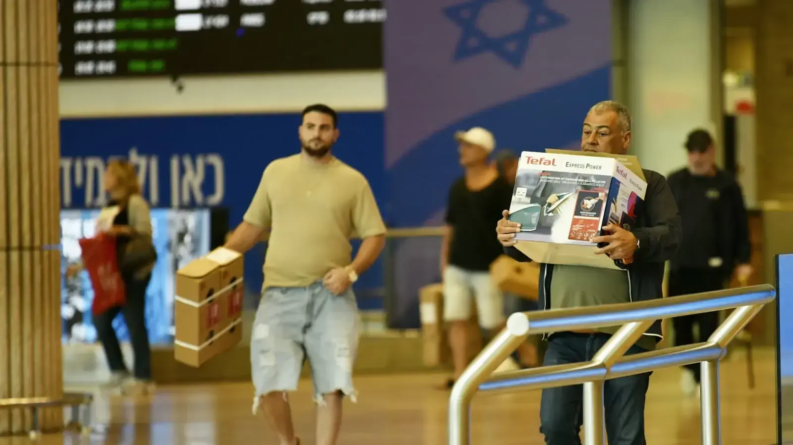 נוסעים אוספים את מוצרי הדיוטי פרי בנתב"ג