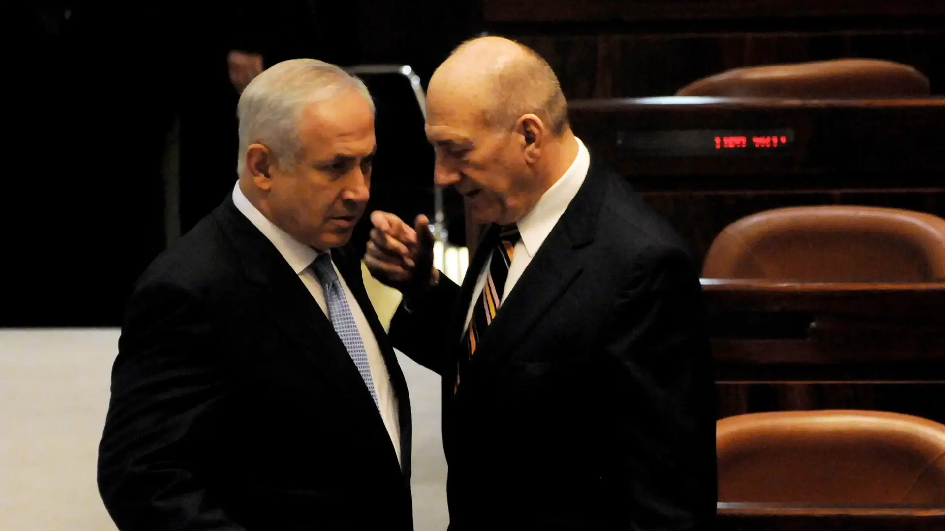 ראש הממשלה המיועד בנימין נתניהו משוחח עם ראש הממשלה היוצא אהוד אולמרט במהלך טקס ההשבעה של הקואליציה החדשה בראשות נתניהו בכנסת, 31 במרץ 2009