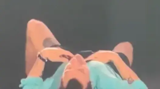 הזמר האנגלי הארי סטיילס נופל לרצפה, לאחר שנחנק ממים, במהלך הופעתו באצטדיון וומבלי, על רקע גל חום קיצוני באנגליה, 26 ביוני 2026