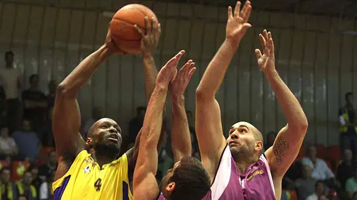 שחקני עירוני נהריה פיליפ ריצ'י עם יוגב אוחיון מנסים לעצור את שחקן הפועל חולון קרטיס וויתרס