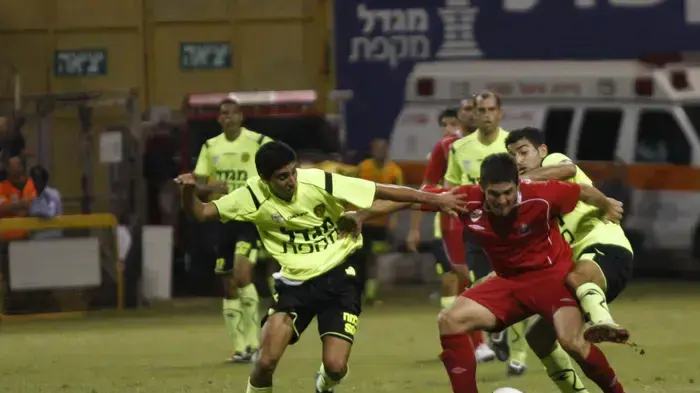 בריאן חרסיסיץ' שחקן הפועל חיפה בין שלו מנשה עם חן עזרא שחקני מכבי נתניה