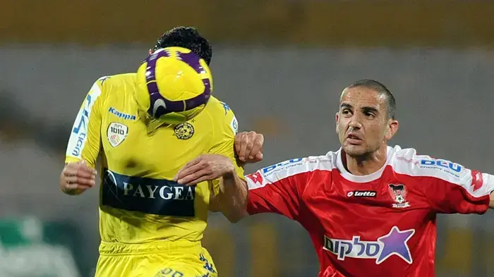 חיים בנון שחקן בני סכנין לצד יוסי שבחון שחקן מכבי תל אביב (מוסתר על ידי הכדור)