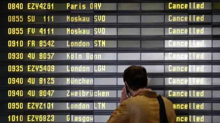 נוסע קורא את לוח הטיסות שבוטלו בנמל התעופה בברלין, גרמניה